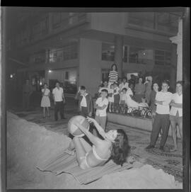 Fotografia "- COPA - CONSEQUENCIA [CONSEQUÊNCIA] DE RESSACA; RESSACAS = EM COPACABANA = AREIA JOGADA NA AV Atlantica [Atlântica] Vera Ortiz dá show de bikini e encima [em cima] da areia jogada na av" ([Local n/d] , 1961) [negativo]. / Fotógrafo(a): L.Santos.  -- ITEM-0004.