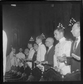 Fotografia "Benção de espadins na Candelária; 'ESCOLA NAVAL' 'CADETES' Benção de Espadins na Igreja da Candelária, entrega de espadim aos novos oficiais da Marinha, servindo de paraninfo do cadete, Mario Ubirajara Hoeke, o Sr. João Etcheverry)" ([Local n/d] , 1963) [negativo]. / Fotógrafo(a): Ferreira.  -- ITEM-0009.