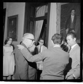 Fotografia "Ministro Evandro Lins com presos Venezuelanos com a Sra. Eunice Torres Calazans, esposa do Sr. José Rodrigues Melo, brasileiro preso na Venezuela, Reportagem de Oscar" ([Local n/d] , 1963) [negativo]. / Fotógrafo(a): Adnré.  -- ITEM-0010.