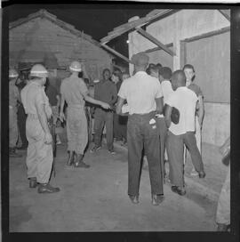 Fotografia "Blitz Policial na Favela do Esqueleto c/ [Duarte]; 'BATIDAS POLICIAIS' 'Blitz' Policial na Favela de Esqueleto, no Maracanã, Reportagem de Duarte" ([Local n/d] , 1963) [negativo]. / Fotógrafo(a): José Gomes; Gomes.  -- ITEM-0003.