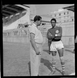 Fotografia "AMERICA F.C.' Rep. c/ Treino do America e reportagem com o goleiro Pompeia em companhia do técnico Daniel Pinto), Reportagem de Esporte" ([Local n/d] , 1963) [negativo]. / Fotógrafo(a): Democrito.  -- ITEM-0008.