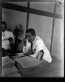 Fotografia "Sr. L. F. Bocayúva Cunha, depondo na 9o. vara, frente aos juízes Castelo Branco e Everaldo Moreira Lima" ([Local n/d] , [Data n/d]) [negativo]. / Fotógrafo(a): [Autoria n/d].  -- ITEM-0008.