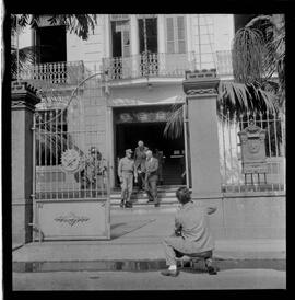 Fotografia "Helio Fernandes na P.E. (Chegada dos advogados, Prado Keli e Prudente de Morais Neto e o presidente do inquérito militar o Gal. Crisanto Figueiredo de Miranda" ([Local n/d] , 1963) [negativo]. / Fotógrafo(a): Rodolfo.  -- ITEM-0004.