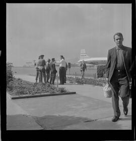 Fotografia "Chegada de Helio [Fernandes]; 'HELIO FERNANDES' Chegada de Helio Fernandes no Aeroporto) (VIDE PAPELETA DO FOTÓGRAFO FERREIRA), Reportagem de Carlos Areias" ([Local n/d] , 1963) [negativo]. / Fotógrafo(a): Ferreira.  -- ITEM-0001.