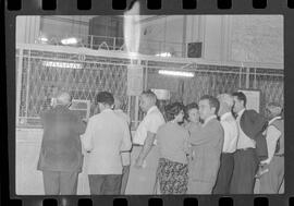 Fotografia "CAIXA DA AMORTIZAÇÃO' Lançamento das Cédulas de Cinco Mil Cruzeiros com filas nos 'guichês' para trocá-las, Reportagem de Caban" ([Local n/d] , 1963) [negativo]. / Fotógrafo(a): Luiz Santos.  -- ITEM-0004.