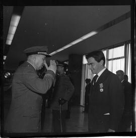 Fotografia "BRASÍLIA - Ministro da Marinha entrega condecorações (medalha do Mérito Naval) à diversas personalidades (Helio de Almeida pelo ministro Silvio Mota) e outros personagens; MEDALHA DO MÉRITO BSB" ([Local n/d] , 1963) [negativo]. / Fotógrafo(a): Neville.  -- ITEM-0007.