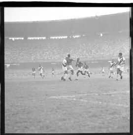 Fotografia "CAMPEONATO CARIOCA DE PROFISSIONAIS DE 1963 (1º TURNO) Jogos - Campeonato Carioca. Flamengo x Madureira (5 x 0) - Vasco x América (2 x 0) e Fluminense x Portuguesa (1 x 1). e Peter Kedzierski, homem voador dos EUA, (Vôo)" ([Local n/d] , 1963) [negativo]. / Fotógrafo(a): Equipe.  -- ITEM-0144.