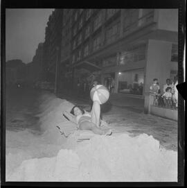 Fotografia "- COPA - CONSEQUENCIA [CONSEQUÊNCIA] DE RESSACA; RESSACAS = EM COPACABANA = AREIA JOGADA NA AV Atlantica [Atlântica] Vera Ortiz dá show de bikini e encima [em cima] da areia jogada na av" ([Local n/d] , 1961) [negativo]. / Fotógrafo(a): L.Santos.  -- ITEM-0003.