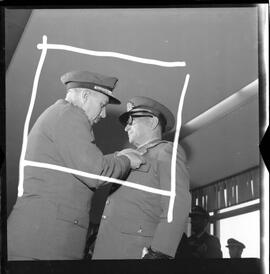 Fotografia "BRASÍLIA - Ministro da Marinha entrega condecorações (medalha do Mérito Naval) à diversas personalidades (Helio de Almeida pelo ministro Silvio Mota) e outros personagens; MEDALHA DO MÉRITO BSB" ([Local n/d] , 1963) [negativo]. / Fotógrafo(a): Neville.  -- ITEM-0008.