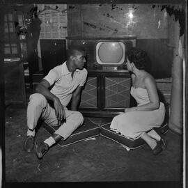 Fotografia "Reportagem com o jogador de futebol Didi do Fluminense na Redação com uma mulher" ([Local n/d] , [Data n/d]) [negativo]. / Fotógrafo(a): Nilo.  -- ITEM-0007.