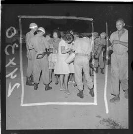 Fotografia "Blitz Policial na Favela do Esqueleto c/ [Duarte]; 'BATIDAS POLICIAIS' 'Blitz' Policial na Favela de Esqueleto, no Maracanã, Reportagem de Duarte" ([Local n/d] , 1963) [negativo]. / Fotógrafo(a): José Gomes; Gomes.  -- ITEM-0005.