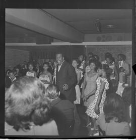 Fotografia "RONDA DAS BUATES [BOITES]; 'RONDA DAS BOITES' ' BOITE AU BON GOUUMET [GOURMET]' 'Ronda das Buartes [Boates]' (Apresentação de Monsueto e suas pastoras), Reportagem de Eli" ([Local n/d] , 1963) [negativo]. / Fotógrafo(a): Roberto.  -- ITEM-0004.