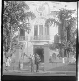 Fotografia "Caso Hélio Fernandes - visitas dos advogados de seus advogados Prado Kelli e Prudente de Morais Neto e sua esposa Sra. Rosinha Fernandes e seu irmão Millor Fernandes, no Quartel da PM), Reportagem de Nelson Silva" ([Local n/d] , 1963) [negativo]. / Fotógrafo(a): Alvaro.  -- ITEM-0013.