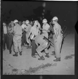 Fotografia "Blitz Policial na Favela do Esqueleto c/ [Duarte]; 'BATIDAS POLICIAIS' 'Blitz' Policial na Favela de Esqueleto, no Maracanã, Reportagem de Duarte" ([Local n/d] , 1963) [negativo]. / Fotógrafo(a): José Gomes; Gomes.  -- ITEM-0009.