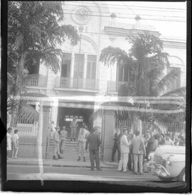 Fotografia "Caso Hélio Fernandes - visitas dos advogados de seus advogados Prado Kelli e Prudente de Morais Neto e sua esposa Sra. Rosinha Fernandes e seu irmão Millor Fernandes, no Quartel da PM), Reportagem de Nelson Silva" ([Local n/d] , 1963) [negativo]. / Fotógrafo(a): Alvaro.  -- ITEM-0007.