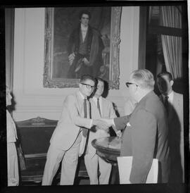 Fotografia "Ministro Evandro Lins com presos Venezuelanos com a Sra. Eunice Torres Calazans, esposa do Sr. José Rodrigues Melo, brasileiro preso na Venezuela, Reportagem de Oscar" ([Local n/d] , 1963) [negativo]. / Fotógrafo(a): Adnré.  -- ITEM-0001.