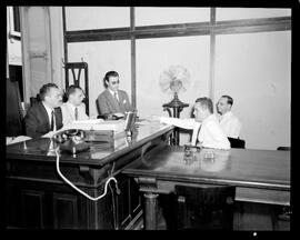 Fotografia "Sr. L. F. Bocayúva Cunha, depondo na 9o. vara, frente aos juízes Castelo Branco e Everaldo Moreira Lima" ([Local n/d] , [Data n/d]) [negativo]. / Fotógrafo(a): [Autoria n/d].  -- ITEM-0003.