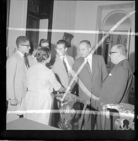 Fotografia "Ministro Evandro Lins com presos Venezuelanos com a Sra. Eunice Torres Calazans, esposa do Sr. José Rodrigues Melo, brasileiro preso na Venezuela, Reportagem de Oscar" ([Local n/d] , 1963) [negativo]. / Fotógrafo(a): Adnré.  -- ITEM-0009.