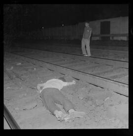 Fotografia "ACIDENTE Pingentes mortos por queda de trem em Mangueira, Paulo da Costa e Nilson Adriano dos Santos, mortos quando viajava como pingente num trem da Central do Brasil, quando foram arrastados por um trem cargueiro, na estação de Mangueira), Reportagem de Mattos" ([Local n/d] , 1963) [negativo]. / Fotógrafo(a): Joel.  -- ITEM-0004.