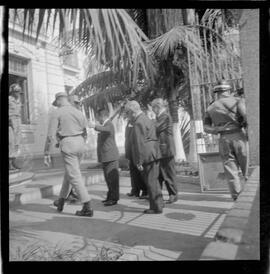 Fotografia "Helio Fernandes na P.E. (Chegada dos advogados, Prado Keli e Prudente de Morais Neto e o presidente do inquérito militar o Gal. Crisanto Figueiredo de Miranda" ([Local n/d] , 1963) [negativo]. / Fotógrafo(a): Rodolfo.  -- ITEM-0017.