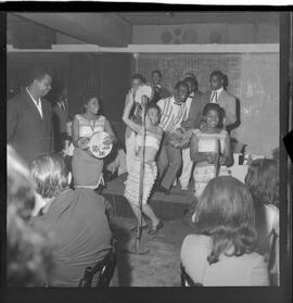 Fotografia "RONDA DAS BUATES [BOITES]; 'RONDA DAS BOITES' ' BOITE AU BON GOUUMET [GOURMET]' 'Ronda das Buartes [Boates]' (Apresentação de Monsueto e suas pastoras), Reportagem de Eli" ([Local n/d] , 1963) [negativo]. / Fotógrafo(a): Roberto.  -- ITEM-0005.