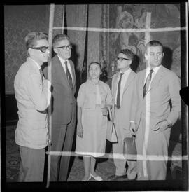 Fotografia "Ministro Evandro Lins com presos Venezuelanos com a Sra. Eunice Torres Calazans, esposa do Sr. José Rodrigues Melo, brasileiro preso na Venezuela, Reportagem de Oscar" ([Local n/d] , 1963) [negativo]. / Fotógrafo(a): Adnré.  -- ITEM-0005.