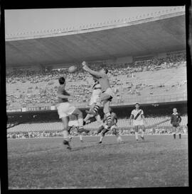 Fotografia "CAMPEONATO CARIOCA DE PROFISSIONAIS DE 1963 (1º TURNO) Jogos - Campeonato Carioca. Flamengo x Madureira (5 x 0) - Vasco x América (2 x 0) e Fluminense x Portuguesa (1 x 1). e Peter Kedzierski, homem voador dos EUA, (Vôo)" ([Local n/d] , 1963) [negativo]. / Fotógrafo(a): Equipe.  -- ITEM-0130.