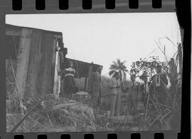 Fotografia "Crime da Invernada de Olaria; 'CRIME DO OPERÁRIO ASSASSINADO PELA INVERNADA DE OLARIA' Crime da Invernada de Olaria (Suite com interrogatório de sua esposa, Berenice Silva dos Santos, pelo promotor Wilson Campelo, interessado no assassinato do operário Djalma Batista dos Santos), Reportagem de Adilson" ([Local n/d] , 1963) [negativo]. / Fotógrafo(a): Luiz Santos.  -- ITEM-0007.