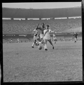 Fotografia "CAMPEONATO CARIOCA DE PROFISSIONAIS DE 1963 (1º TURNO) Jogos - Campeonato Carioca. Flamengo x Madureira (5 x 0) - Vasco x América (2 x 0) e Fluminense x Portuguesa (1 x 1). e Peter Kedzierski, homem voador dos EUA, (Vôo)" ([Local n/d] , 1963) [negativo]. / Fotógrafo(a): Equipe.  -- ITEM-0132.